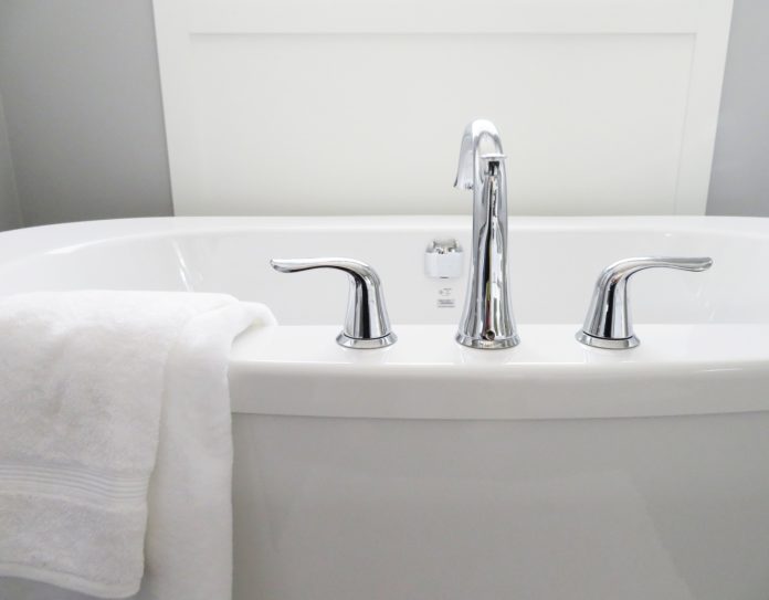 sparkling clean bathroom tub with white towel