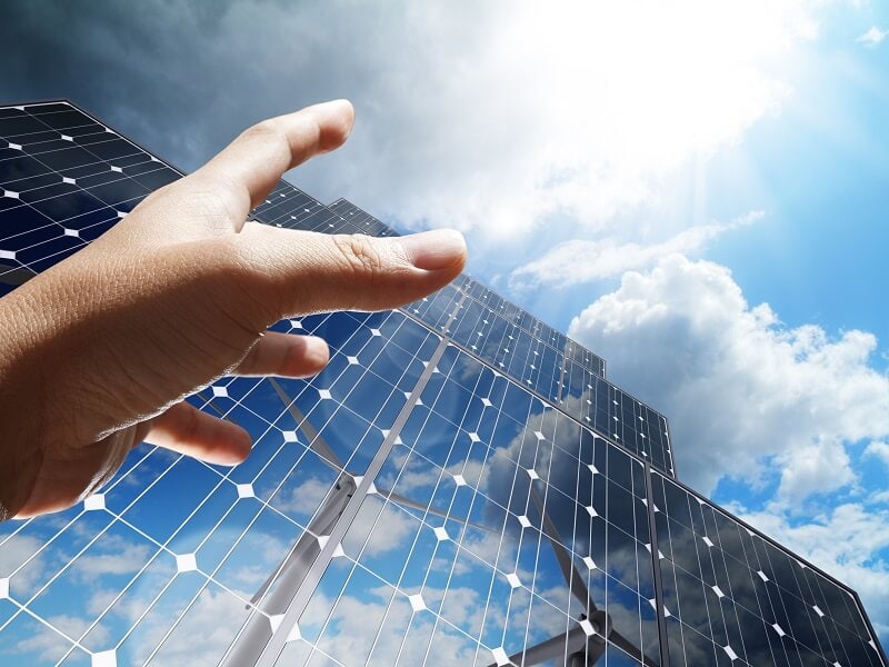 hand reaching for solar panels