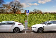 Two white electric cars charging at a charging station