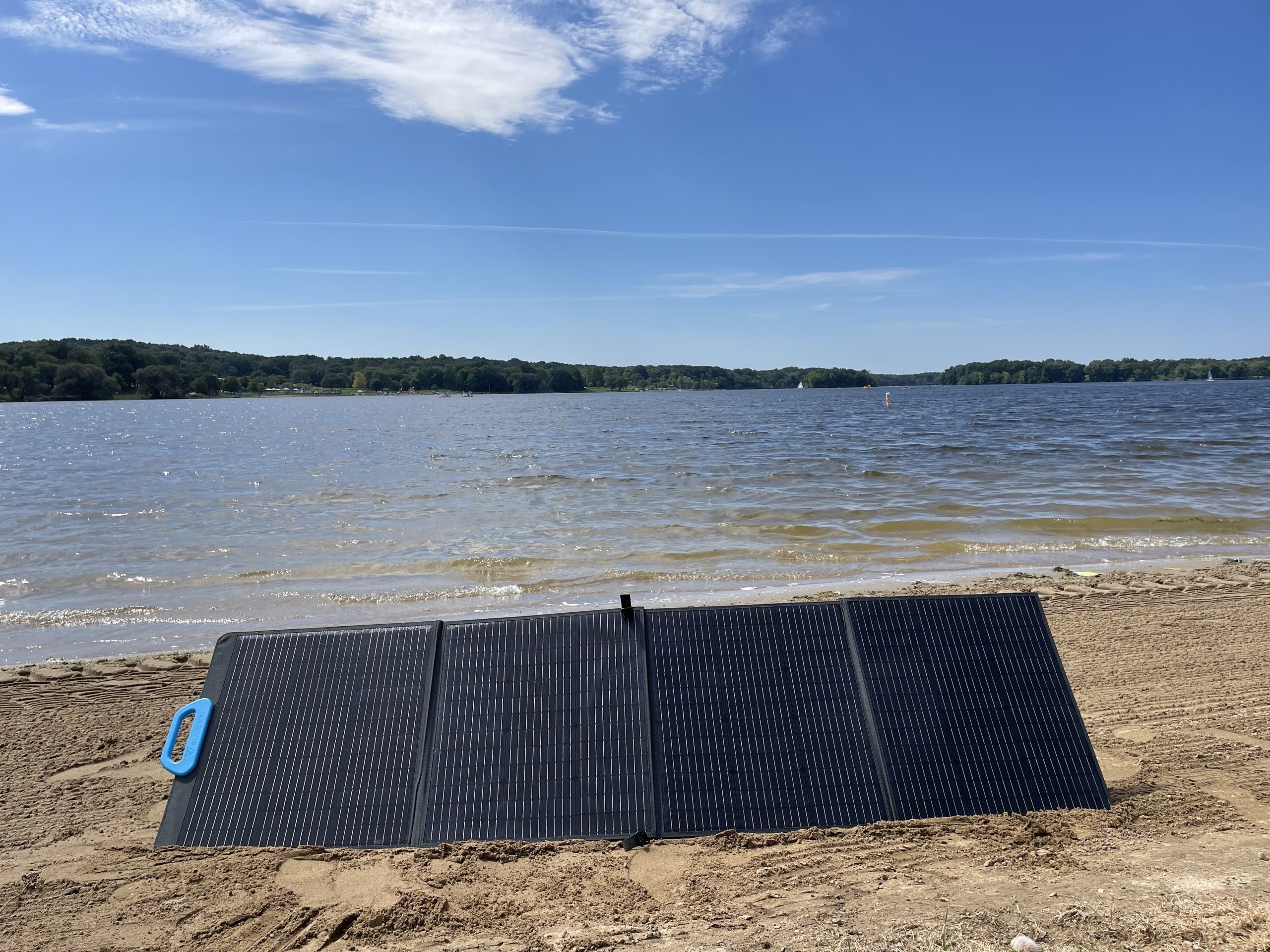 bluetti PV200 solar panel on a sandy beach with a lake in the background