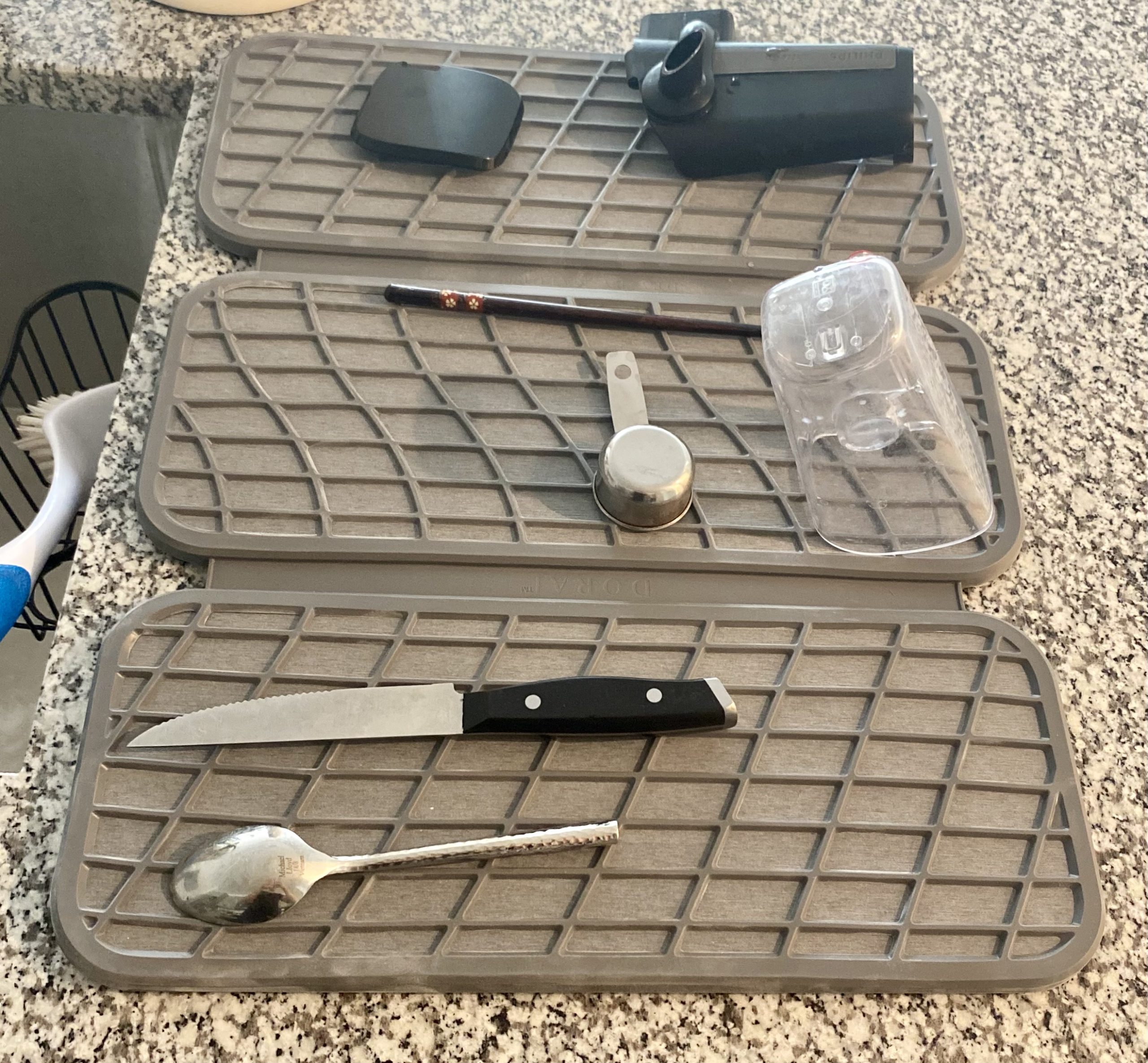 dorai dish drying mat with cutlery and kitchen utensils drying on it