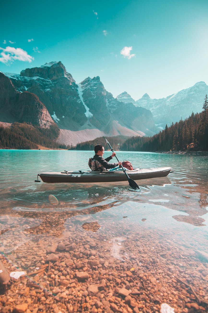 person riding on gray kayak